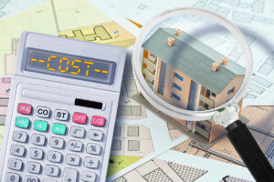 Cost of apartment roof replacement concept - calculator saying "cost" and magnifying glass on an apartment roof building